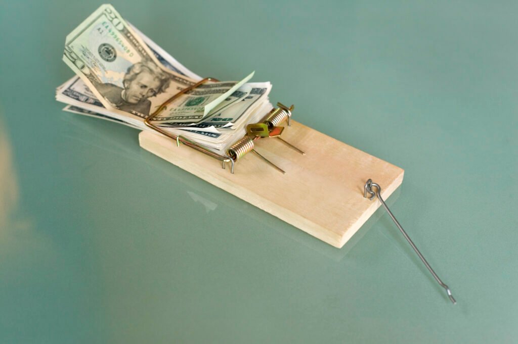 An image showing a mousetrap with money it is, showing that home solutions may be expensive in the long run.