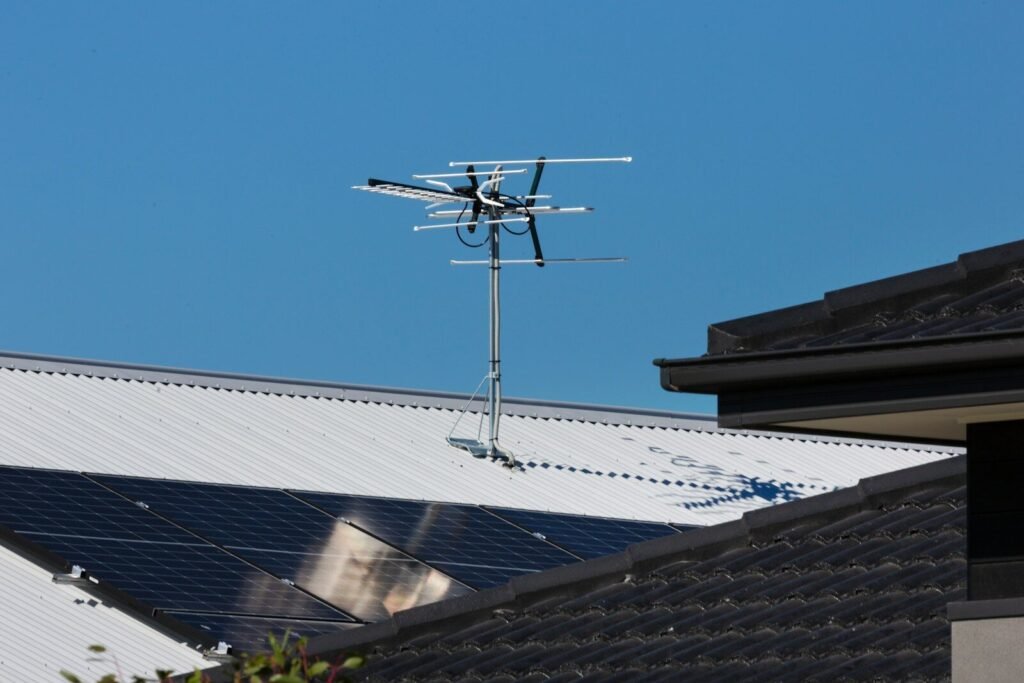 A television antenna stands tall against a clear blue sky